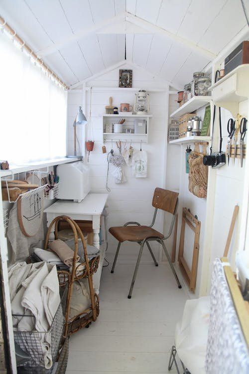 a small room with shelves and chairs in it