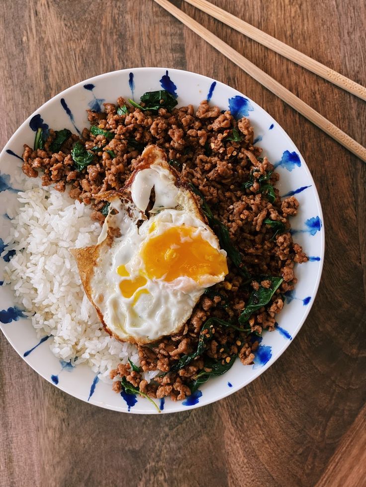 a plate with rice, meat and an egg on it