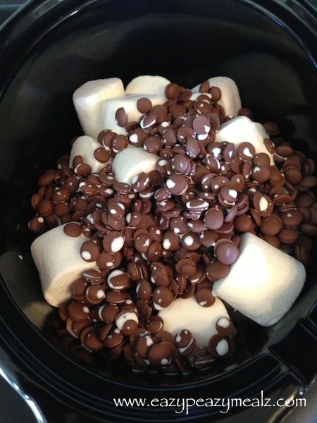 a crock pot filled with marshmallows and chocolate chips on top of it