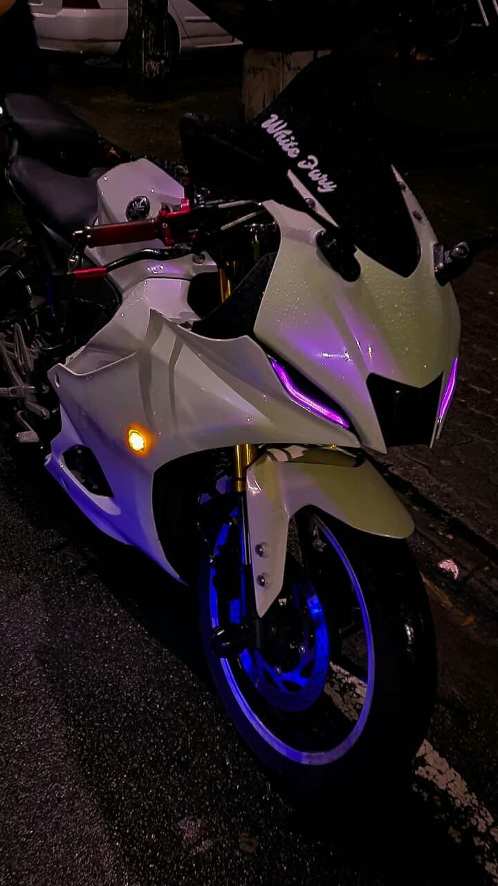 a white and blue motorcycle is parked on the side of the road at night time