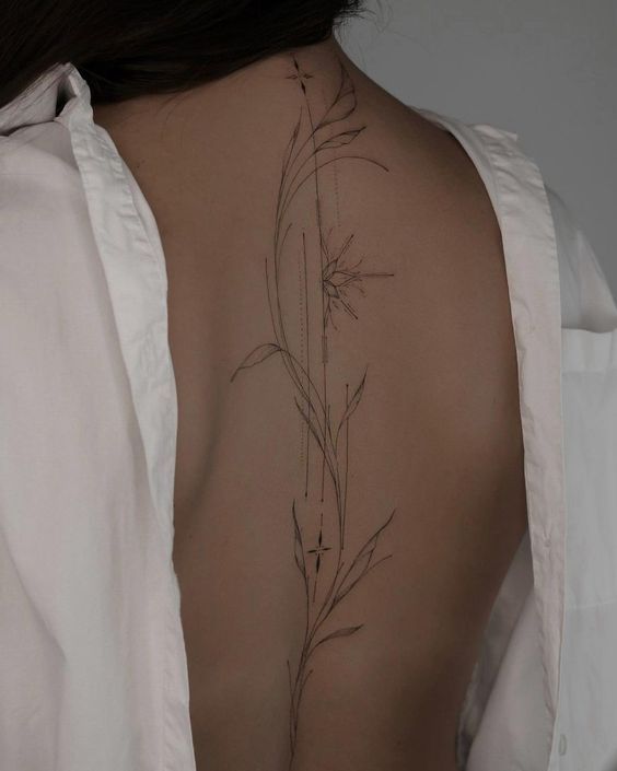 the back of a woman's body with flowers on her left arm and shoulder