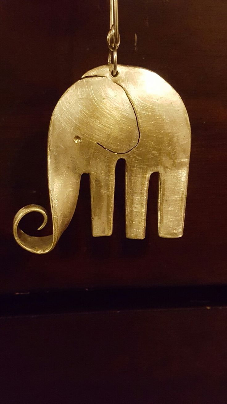 a gold elephant charm hanging from a chain