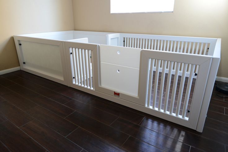 an empty room with wooden flooring and white railings on the wall, in front of a window