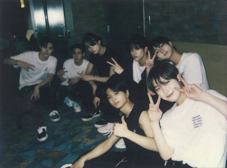 a group of young men sitting next to each other on top of a carpeted floor