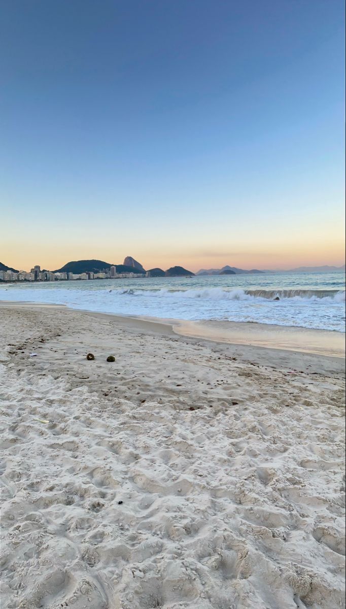 an empty beach with footprints in the sand