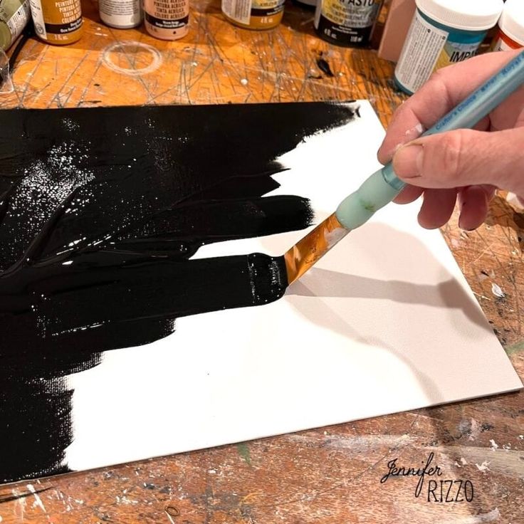 a person is painting with black and white paint