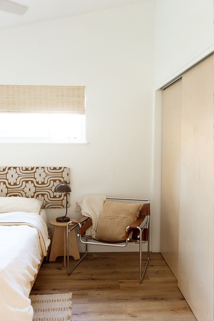 a bed sitting next to a window in a bedroom on top of a hard wood floor