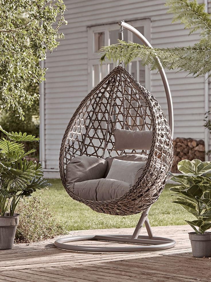 an outdoor swing chair with grey cushions