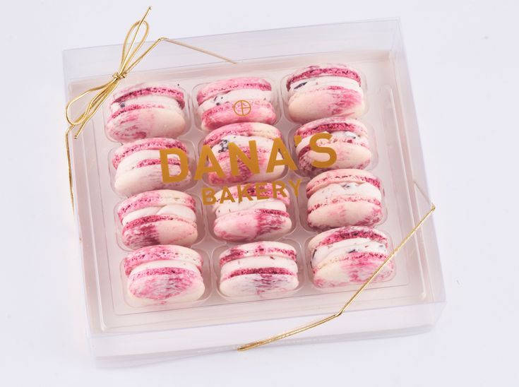 a box filled with pink and white donuts