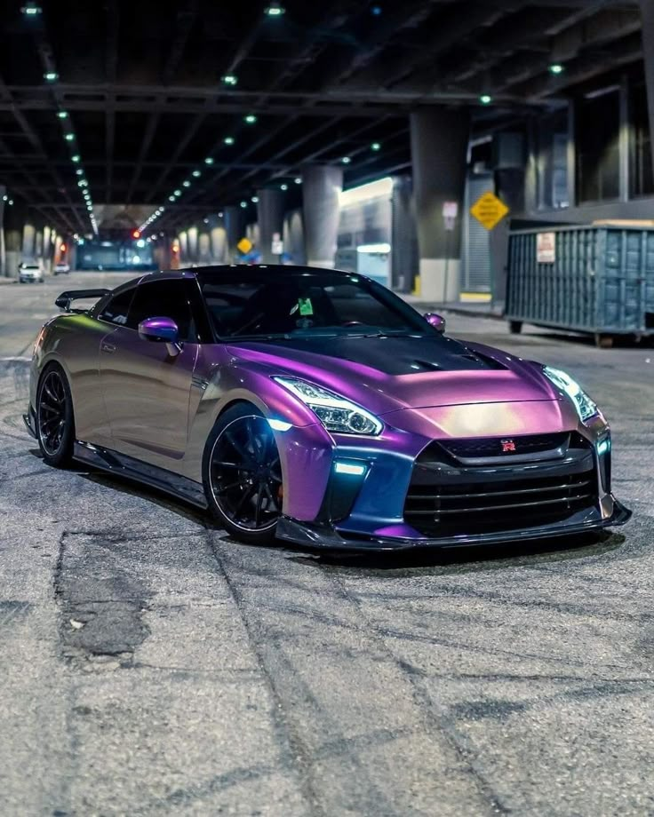 a purple and black sports car parked in an empty parking garage with no one around