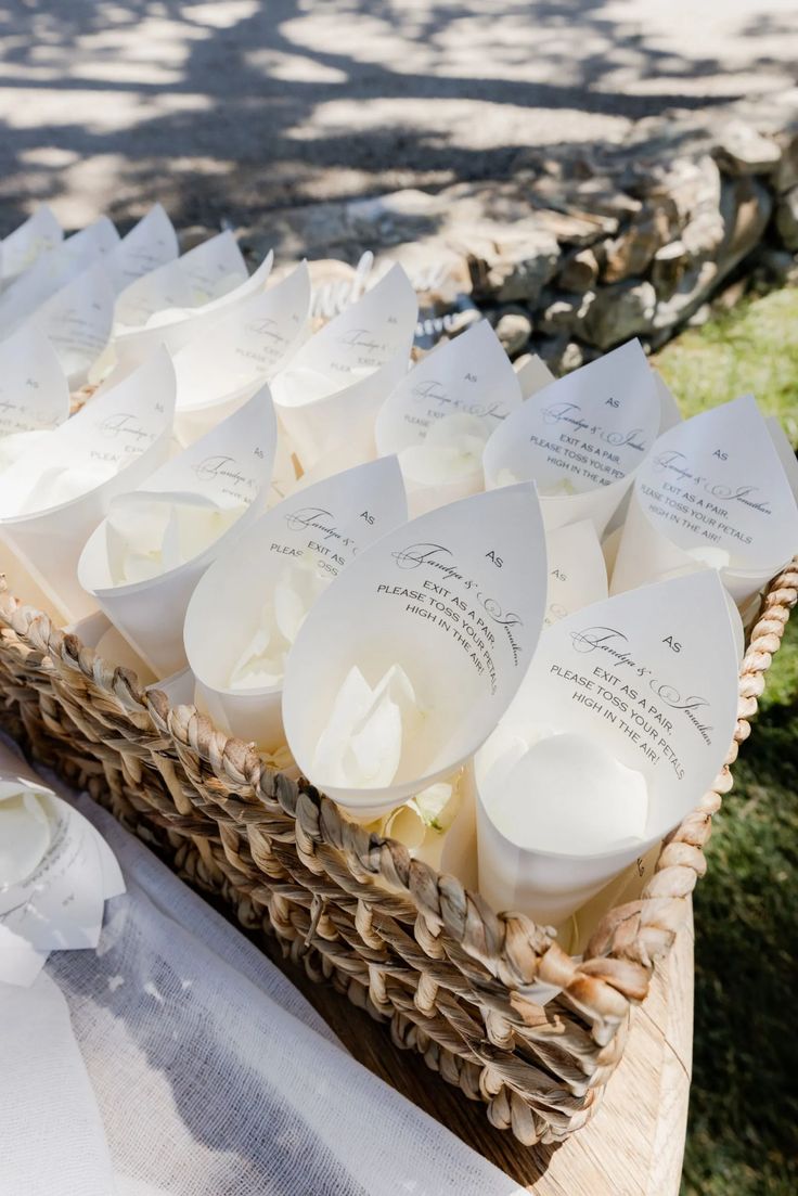 a basket filled with lots of white cupcakes on top of a table