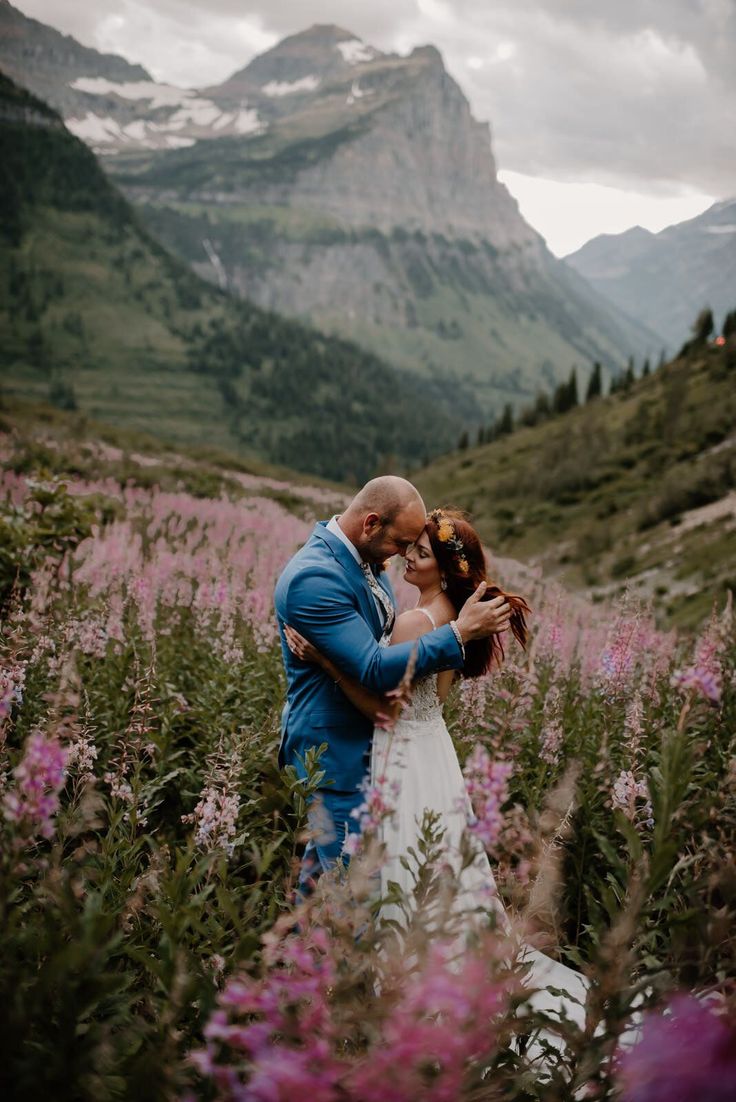 a bride and groom embracing in the mountains