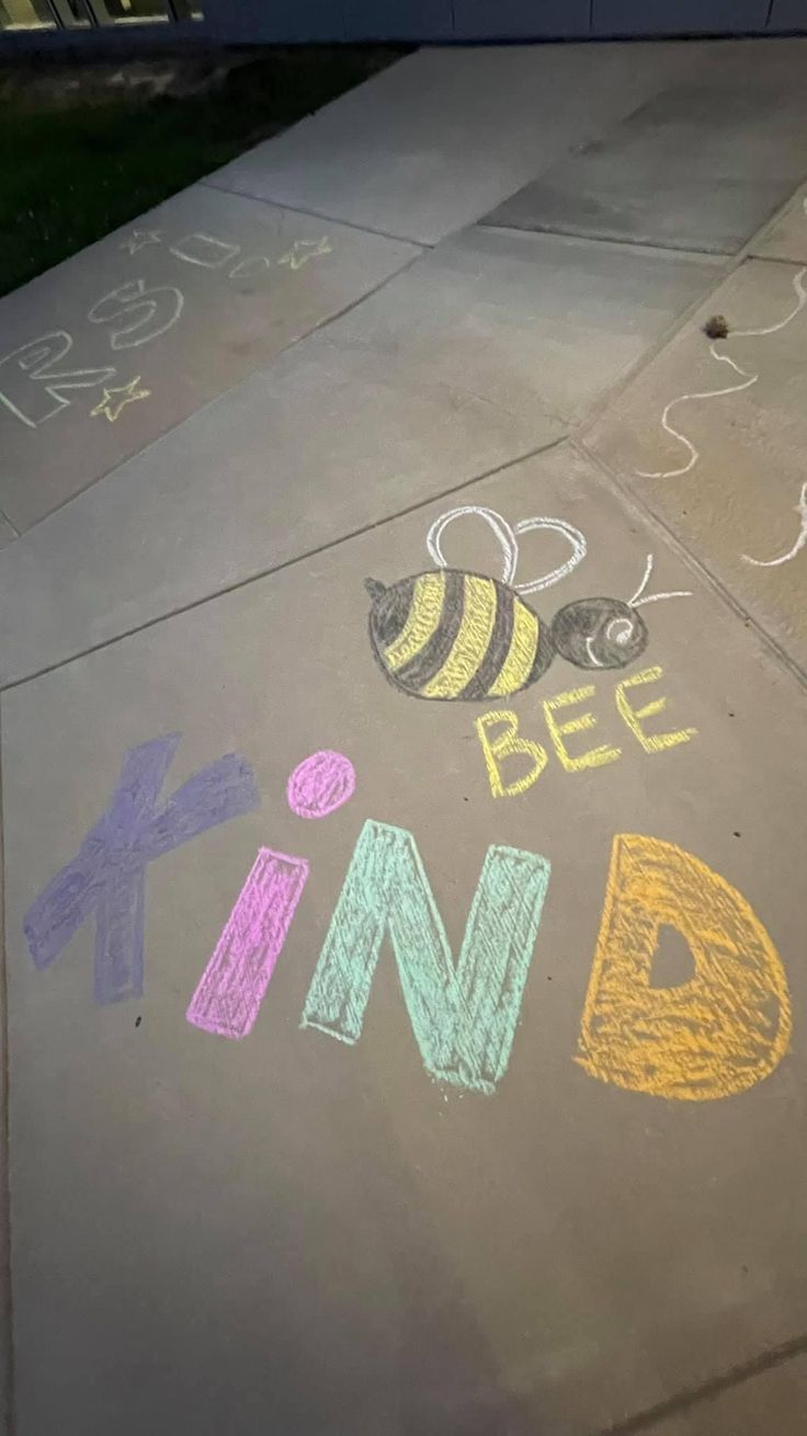 the sidewalk has been decorated with chalk and crayons to spell out bee kind