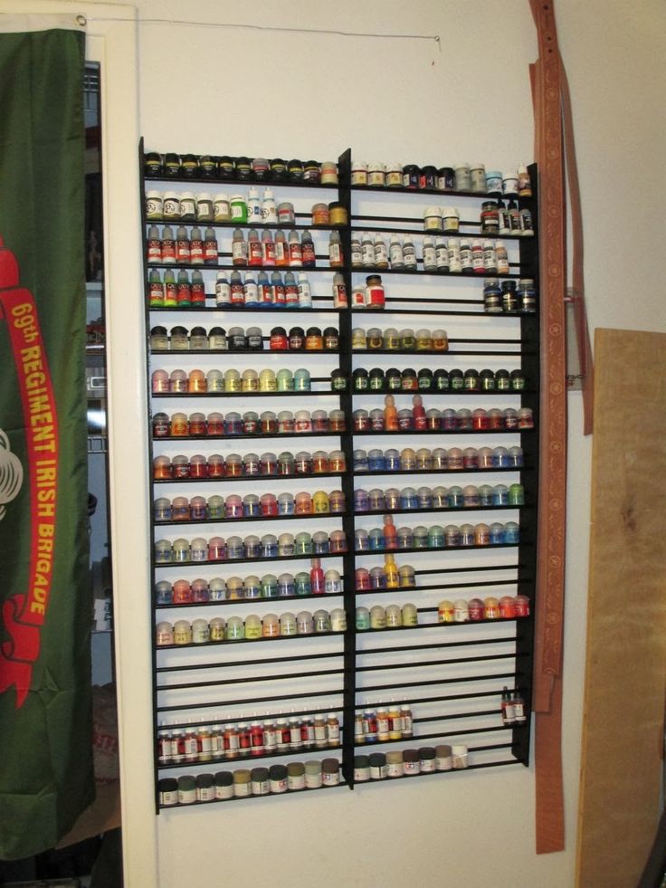 a room with a rack full of beer bottles and cans on the wall next to a door