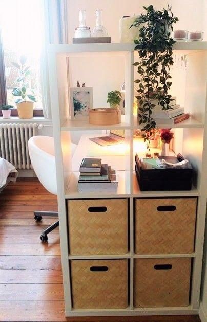 a white shelf with drawers and plants on top