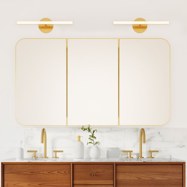 a bathroom with two sinks, mirrors and gold faucets on the countertop