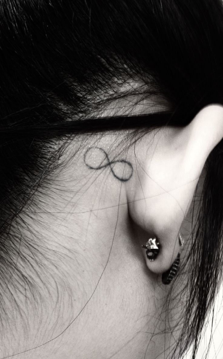 a woman's ear with an infinite sign tattoo on her left behind the ear