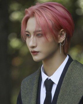 a young man with pink hair wearing a suit and tie