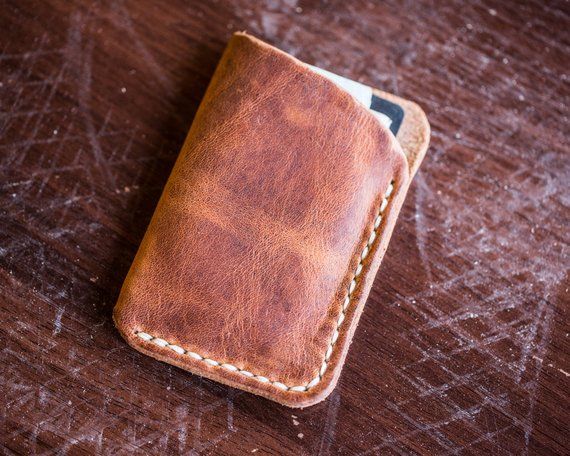 a leather wallet sitting on top of a wooden table