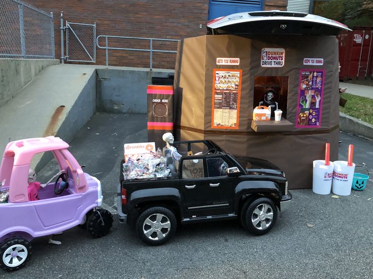 two toy cars parked next to each other in front of a small booth on the street