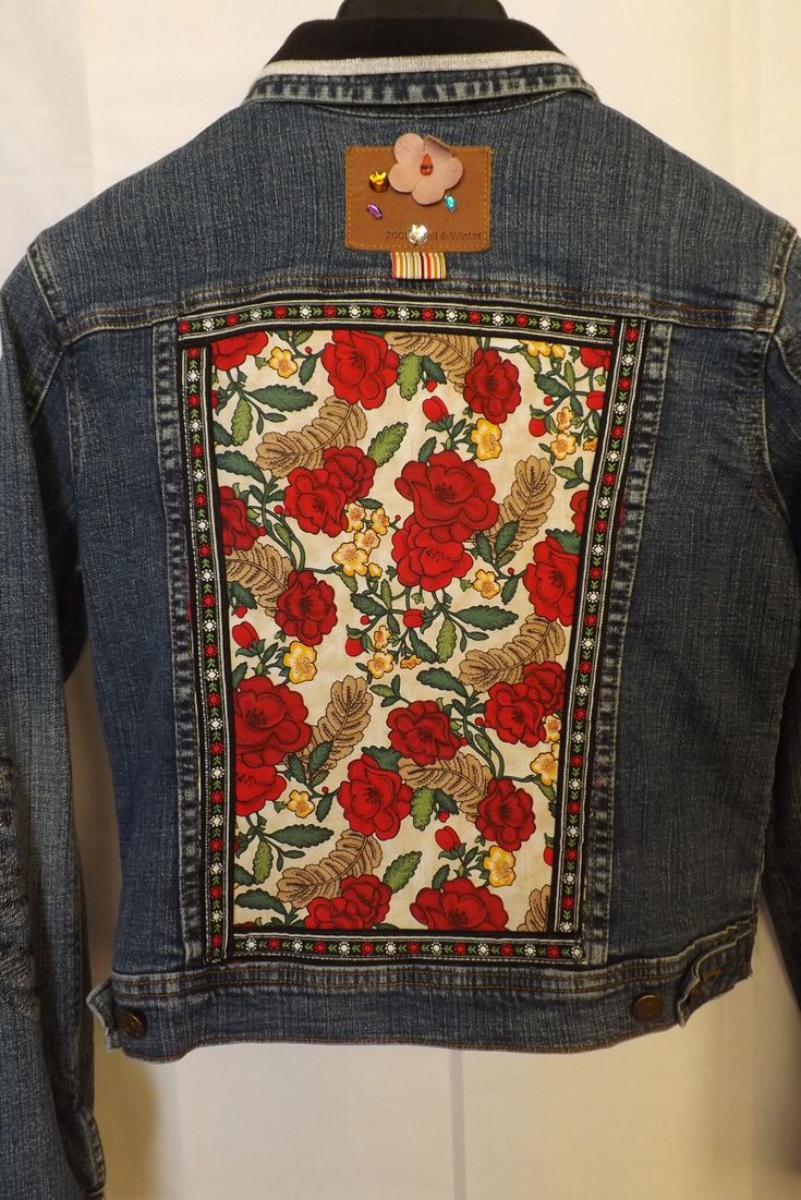 a denim jacket with red flowers on it