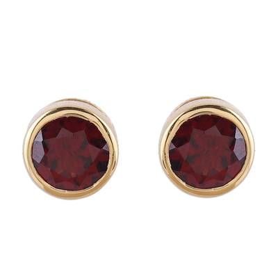 Bathed in 22k gold with a high-polish finish sterling silver frames two stones of faceted garnet. Alok Jain presents this sparkling pair of stud earrings crafted by local artisans. Yellow Gold Garnet Round Earrings, Classic Birthstone Earrings For Formal Occasions, Gold Garnet Jewelry With Bezel Setting, Formal Gold Bezel Set Earrings, Classic Ruby Birthstone Earrings, Gold Faceted Ruby Earrings, Gold Faceted Garnet Earrings, Gold Garnet Faceted Earrings, Faceted Garnet Earrings In Gold