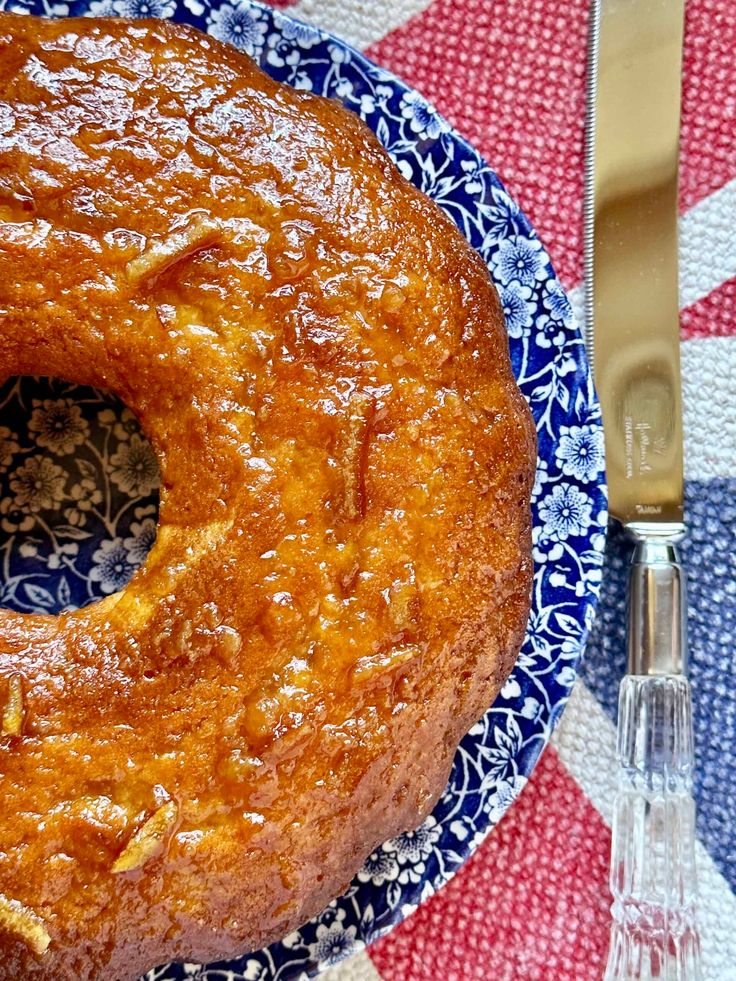 a bundt cake sitting on top of a blue and white plate next to a fork