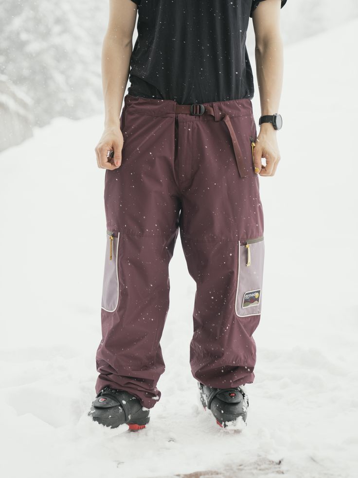 a man standing in the snow with his skis on and one foot propped up