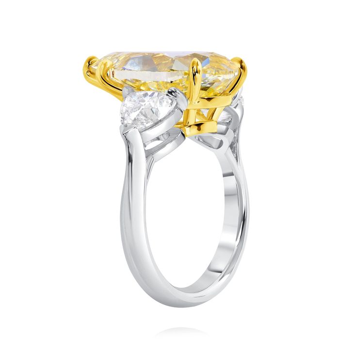 a yellow and white diamond ring with two stones on the side, set in 18k gold