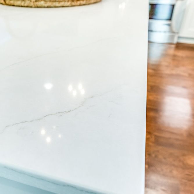 a white counter top in a kitchen with wood flooring and a basket on it