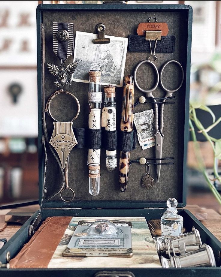 an open suitcase filled with lots of assorted items on top of a wooden table