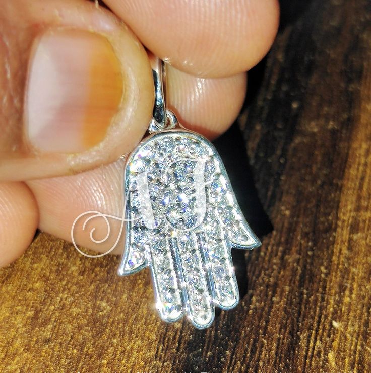 ▪️ TITLE Hip hop Men's Women's 925 Silver Iced Out Certified Moissanite Diamond Evil Eye Hamsa Hand Pendant Rhodium or 14k White Gold Finish Gift For Her, Gift for rapper ▪️ ITEM DESCRIPTION Main Stone Carat Weight : 2Ct Main Stone Shape : Round Main Stone Color : White ▪️ Available In : 925 Sterling Silver, 14K White Gold Plated, 14K Rose Gold Plated, 14K Yellow Gold Plated, 10K White Gold, 14K White Gold, 18K White Gold ▪️ SHIPPING It usually takes 7 -10 days to make and 9-15 days to ship We a Hand Set Sterling Silver Pendant Jewelry, Spiritual Silver Jewelry With Diamond Cut, Dazzling Sterling Silver Jewelry Stamped 925, Dazzling 925 Stamped Sterling Silver Jewelry, Silver Moissanite Necklace, Symbolic Silver Diamond Jewelry, Spiritual Silver Cubic Zirconia Jewelry, Silver Spiritual Jewelry With Cubic Zirconia, Spiritual Silver Jewelry With Cubic Zirconia