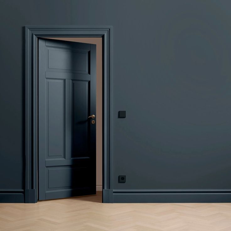 an open door in a dark room with parquet flooring and walls painted blue