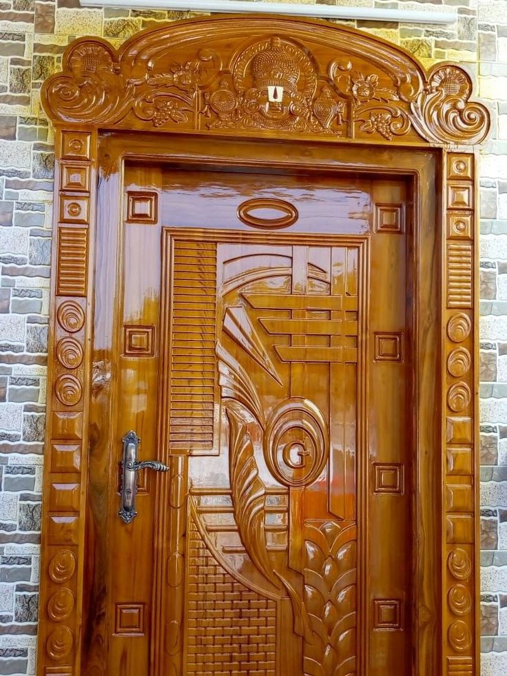 an ornate wooden door on a brick wall