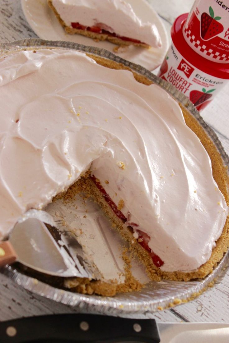 a pie that has been cut in half and is on a table next to a can of yogurt