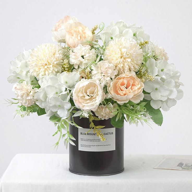 a vase filled with white and pink flowers on top of a table