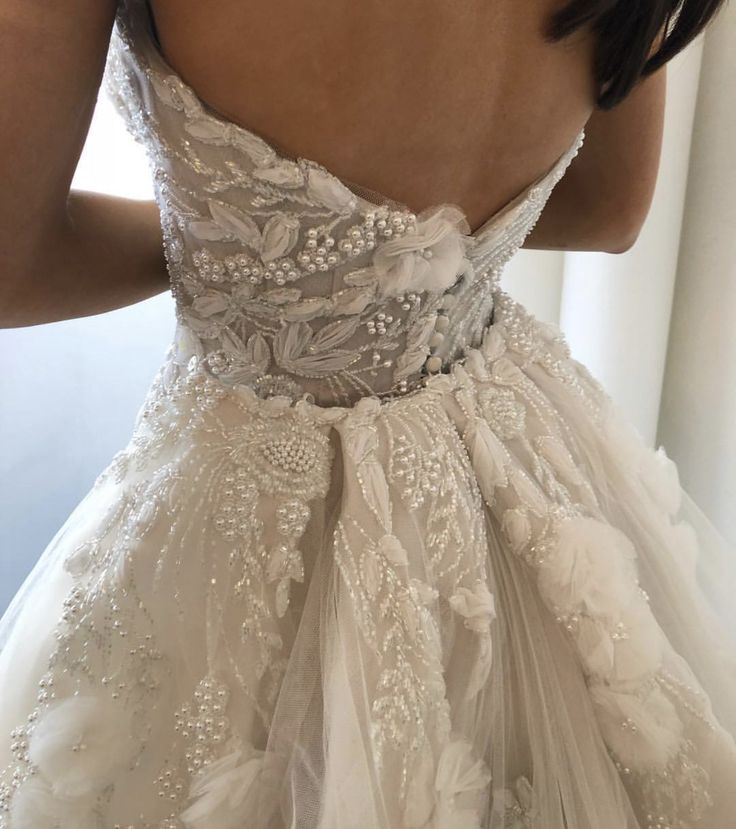 a woman in a wedding dress looking at her reflection