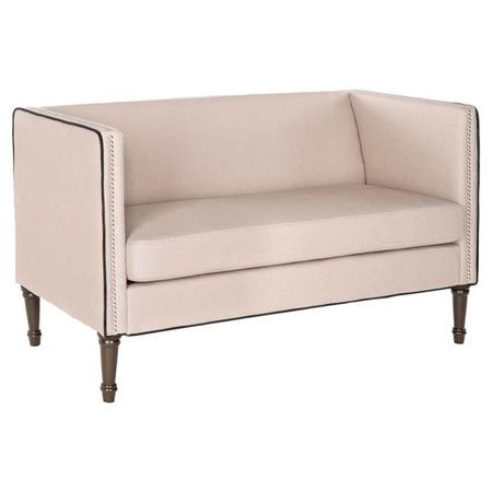 a cream colored couch with wooden legs and studding on the arm rests against a white background