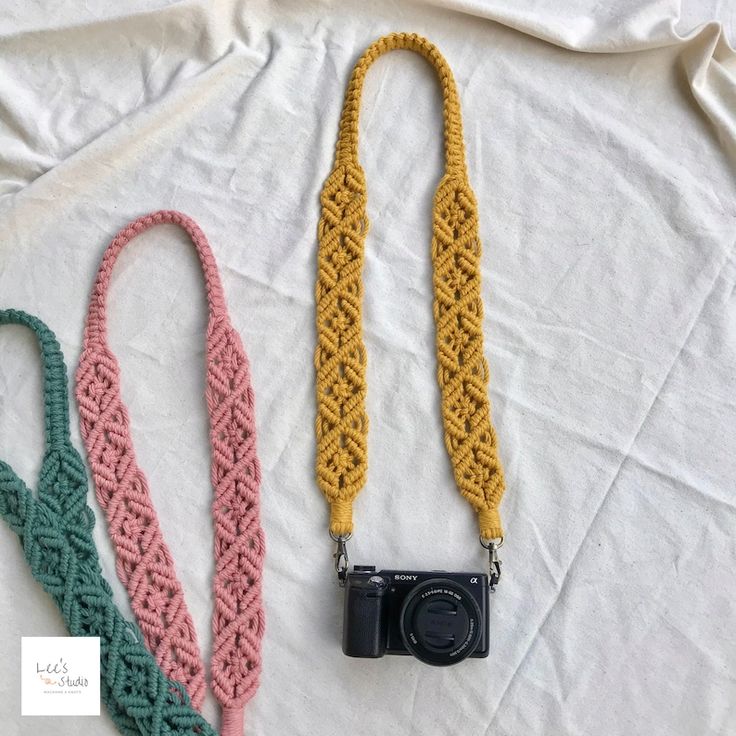 three crocheted lanyards with camera attached to them on a white sheet