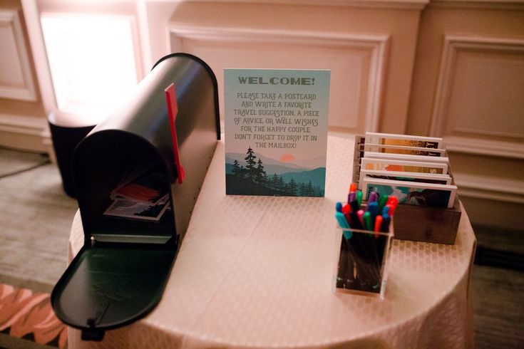 a mailbox sitting on top of a table next to some pens and pencils