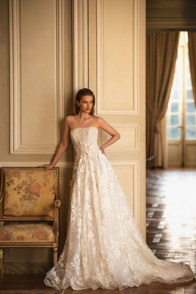 a woman in a wedding dress leaning against a wall