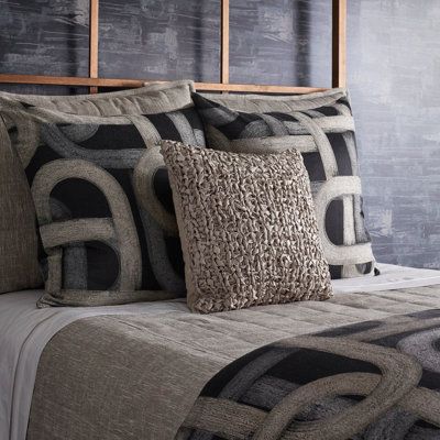 a bed topped with lots of pillows next to a wall covered in chalkboard walls