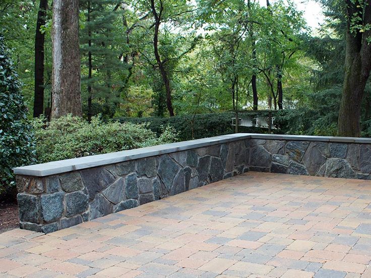 a stone bench sitting on top of a brick walkway