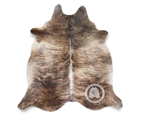 a brown and white cowhide rug on a white background