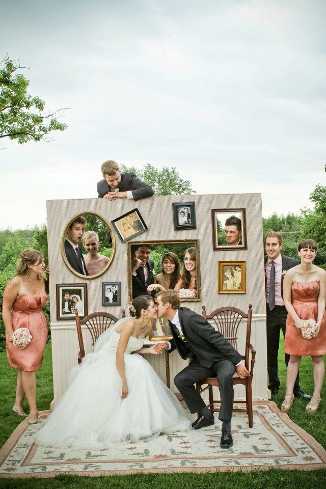 a bride and groom kissing in front of a photo booth with pictures on the wall