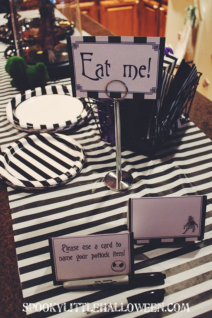 a table set up for a party with place cards and napkins on it that say eat me