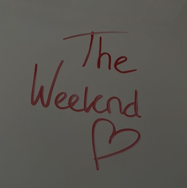 the word the weekend is written in red ink on a white board with a heart