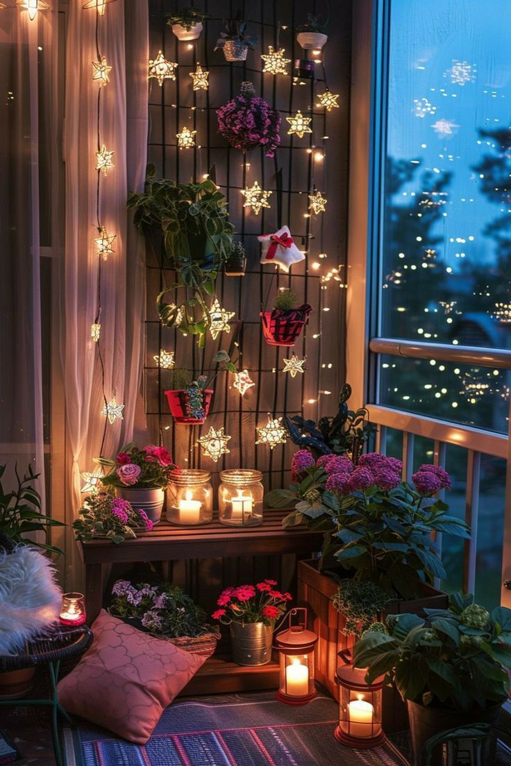 a balcony with potted plants, candles and lights on the windowsill at night