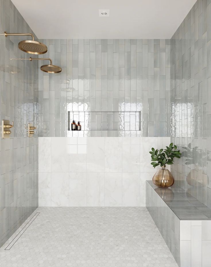 a white tiled bathroom with gold fixtures and plants in the shower area, along with marble counter tops