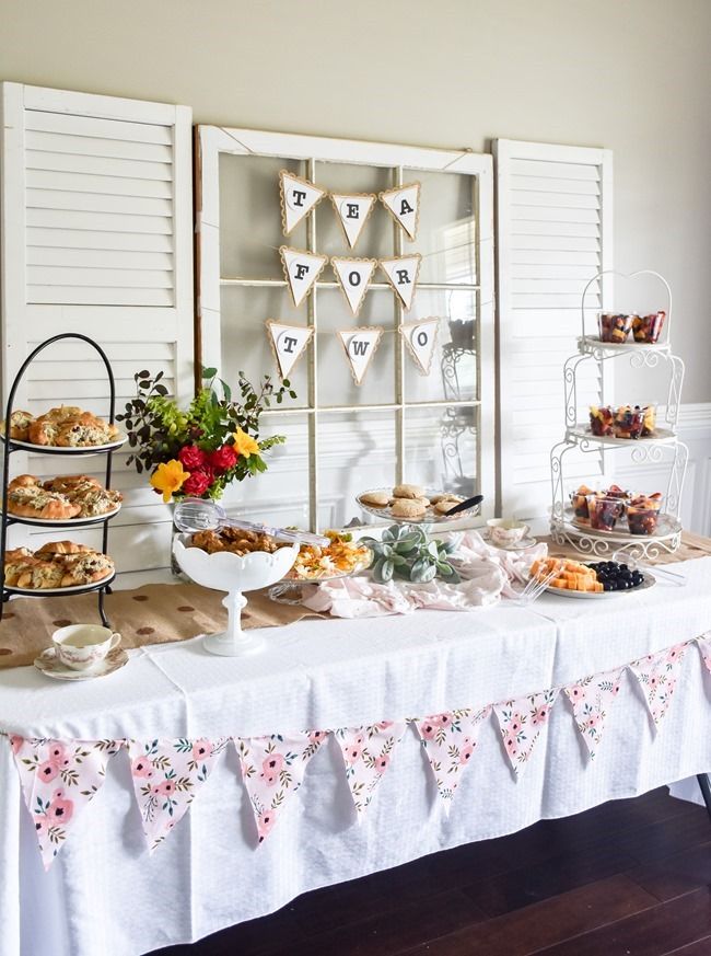 a table topped with lots of food next to white shutters